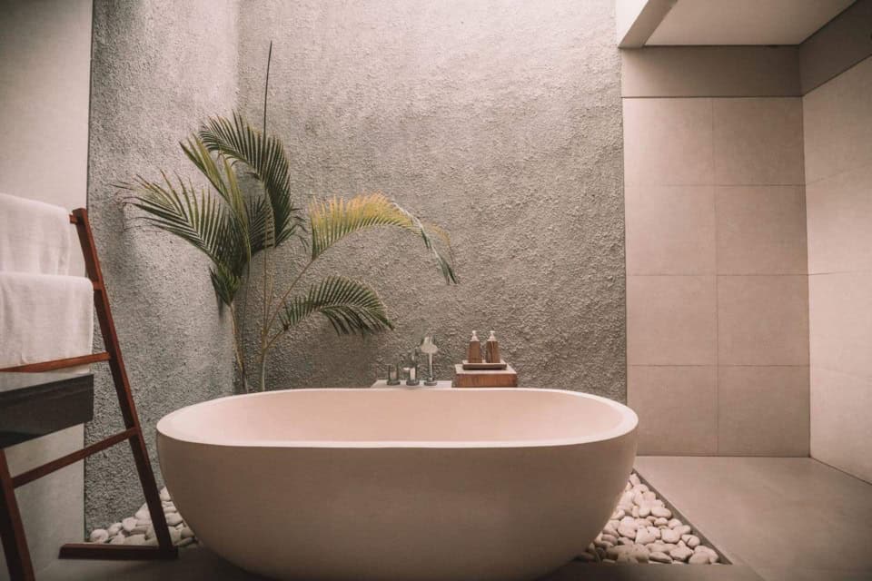 Cadă de baie albă într-o baie minimalistă